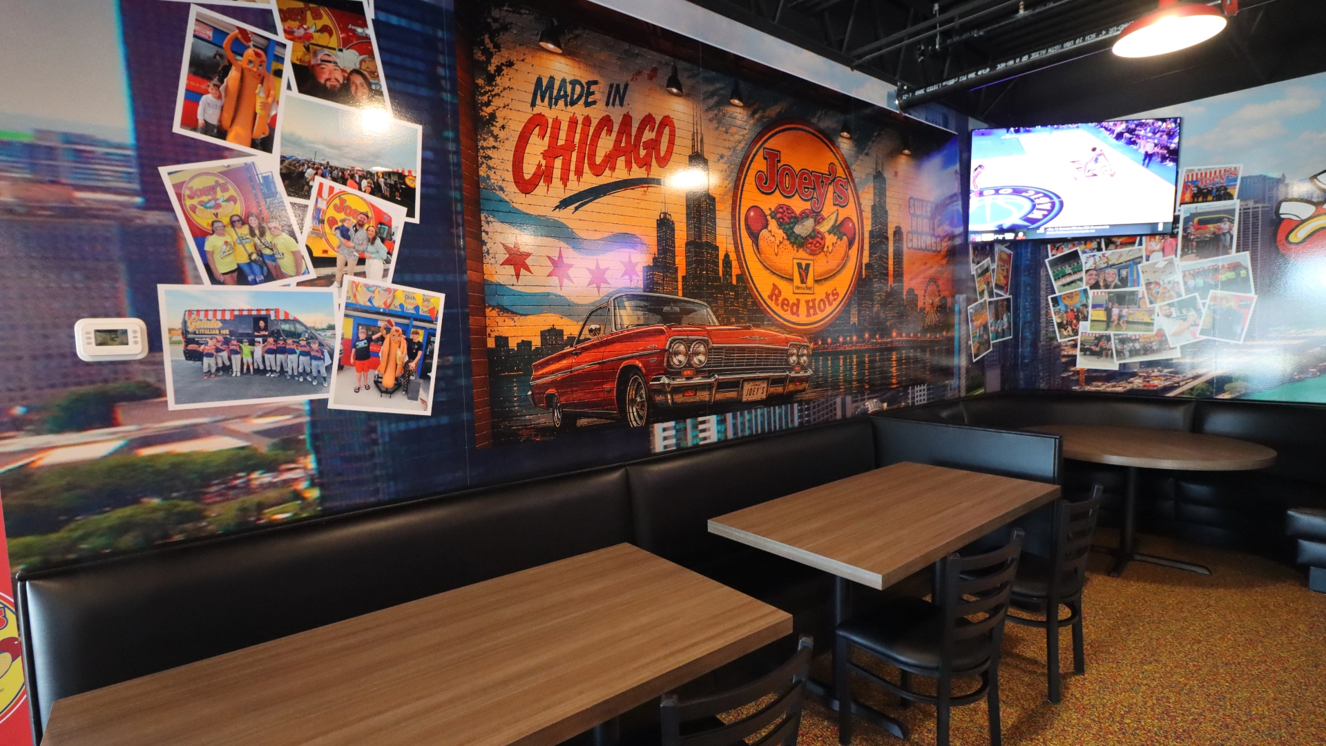 Large dining room inside the new Joey's Red Hots location in Orland Park with tables, murals and service counter